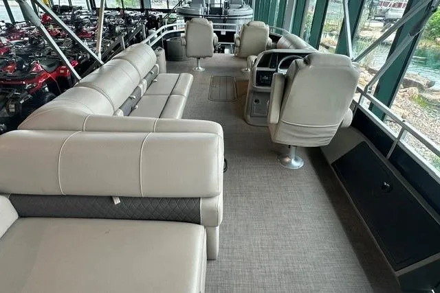 Slide: The Image of 2025 Sun Tracker Sportfish 24 XP3 pontoon boat interior with beige seating and helm station. - 4