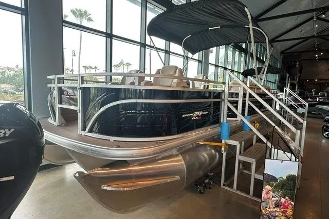 The Image of 2025 Sun Tracker Sportfish 24 XP3 pontoon boat displayed indoors with canopy and seating. - 0