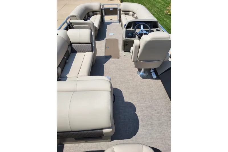 Slide: The Image of 2025 Sun Tracker SportFish 22 XP3 pontoon boat interior with plush seating and steering console. - 2