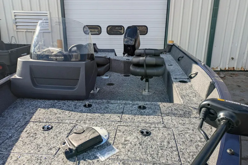 Slide: The Image of 2025 Tracker Pro Guide V-16 SC fishing boat interior with seating and controls. - 2
