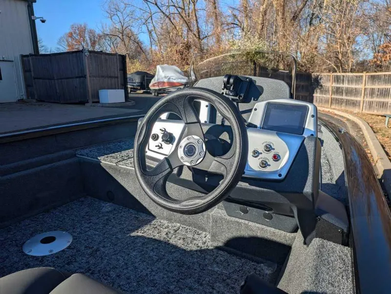 Slide: The Image of 2025 Tracker Pro Team 175 Crappie Edition boat dashboard with steering wheel and controls. - 2
