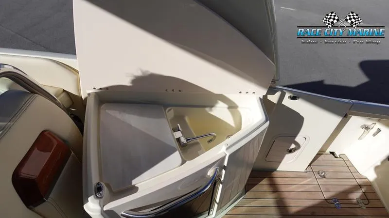 Slide: The Image of 2025 Chris-Craft 28GT boat sink and deck area, featuring sleek design and wood finish. - 26