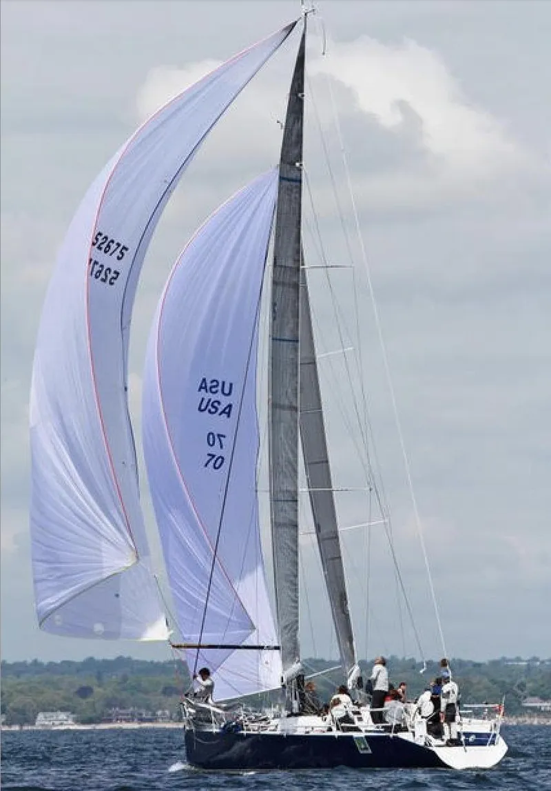 Slide: The Image of Sailboat Ker 11.3, 2001 model, with crew sailing on open water. - 1