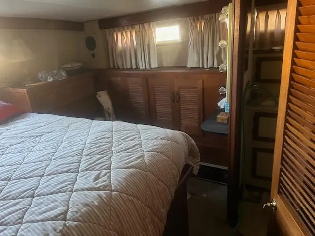 Slide: The Image of Cozy bedroom interior of 1981 Viking 43 DC yacht with wood paneling and quilted bedding. - 19