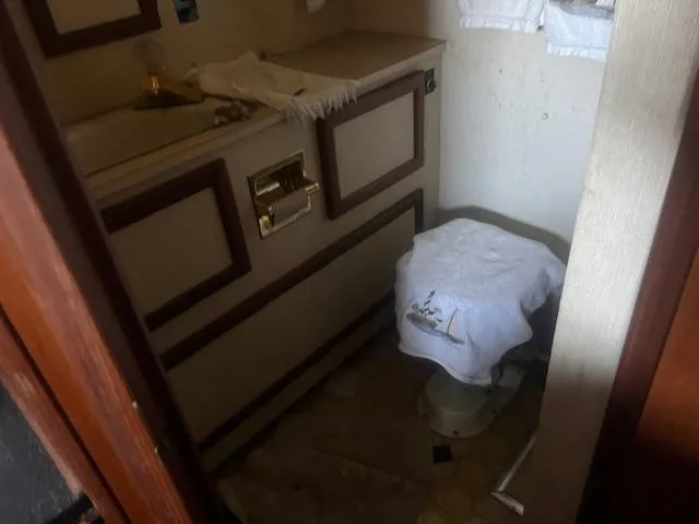 Slide: The Image of 1981 Viking 43 DC bathroom with sink, cabinet, and covered toilet. - 21
