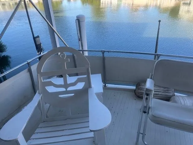 Slide: The Image of 1981 Viking 43 DC boat deck with chairs overlooking calm water. - 24