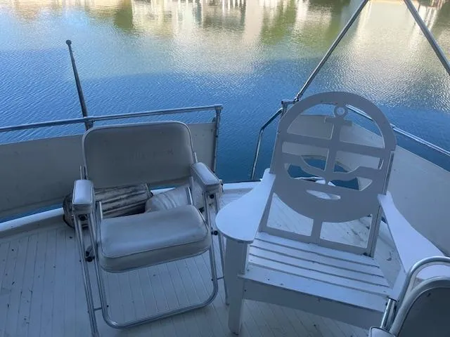 Slide: The Image of 1981 Viking 43 DC yacht deck with chairs overlooking serene water. - 25