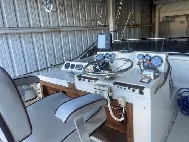 Slide: The Image of 1981 Viking 43 DC boat helm with steering wheel, gauges, and navigation equipment. - 27