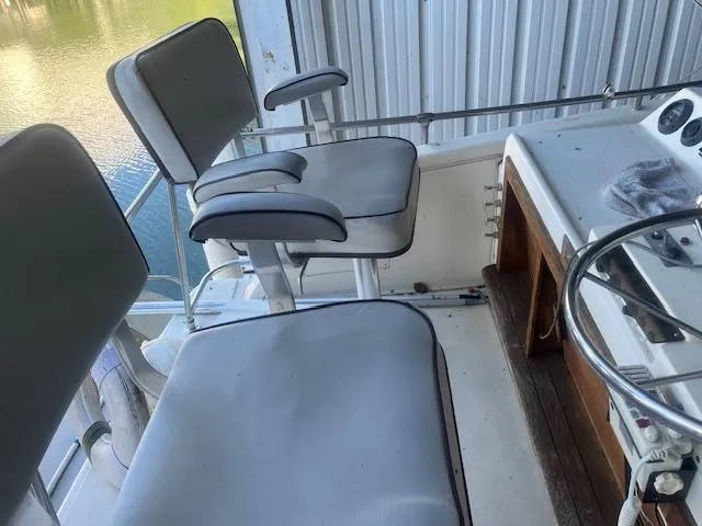 Slide: The Image of 1981 Viking 43 DC boat helm with two cushioned seats and steering wheel. - 28