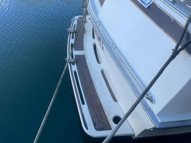 Slide: The Image of 1981 Viking 43 DC boat stern view with wooden deck, docked on calm water. - 4