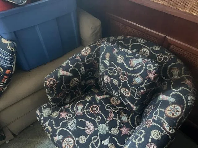 Slide: The Image of Patterned armchair with nautical design, blue storage bin, and beige sofa in a cozy room. - 7