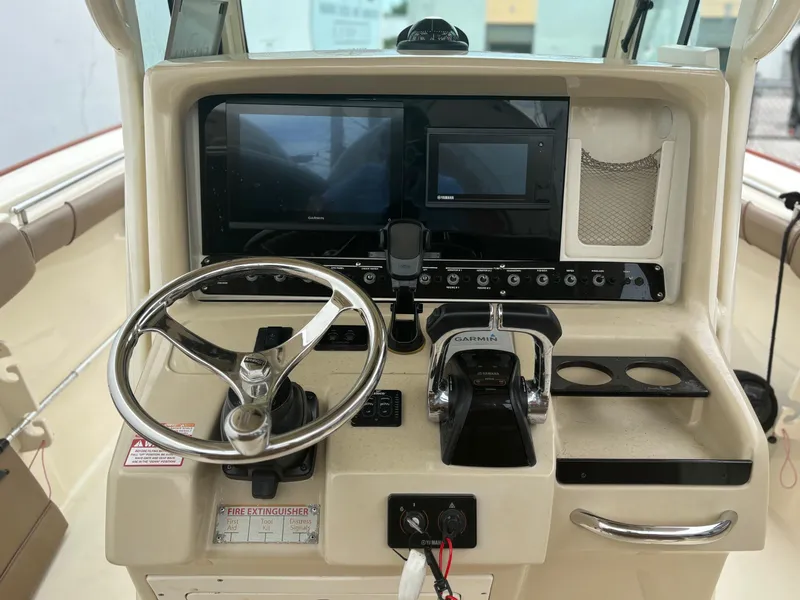 Slide: The Image of 2013 Scout 275 LXF boat dashboard with steering wheel and control panel. - 14