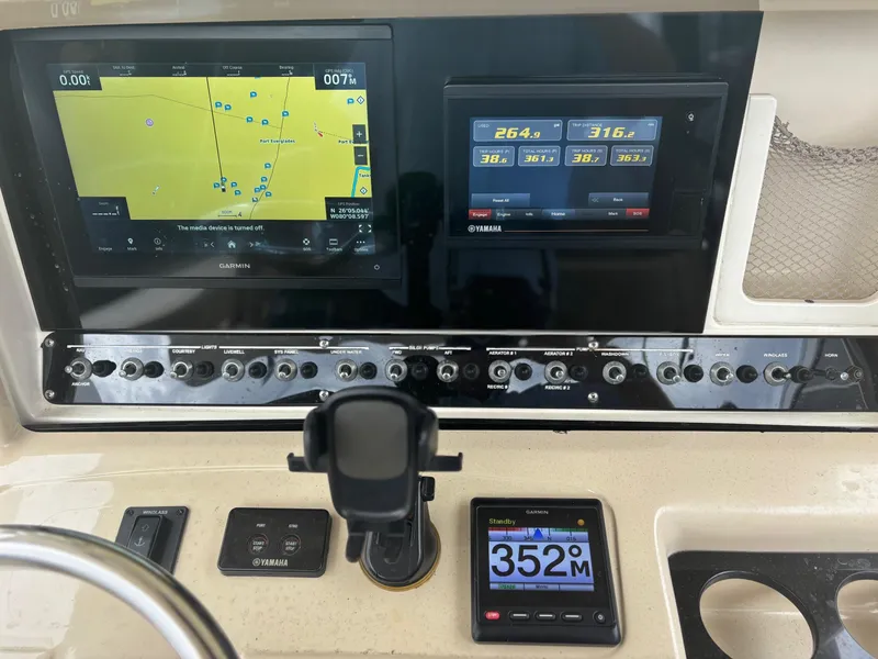 Slide: The Image of Dashboard of 2013 Scout 275 LXF boat with navigation and control panels. - 16