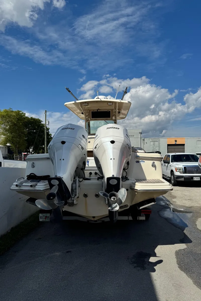 Slide: The Image of 2013 Scout 275 LXF boat with dual outboard engines, parked outdoors. - 7