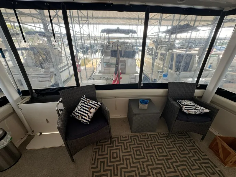 Slide: The Image of 1989 Sea Ray 39 yacht interior with wicker chairs, patterned cushions, and marina view. - 13