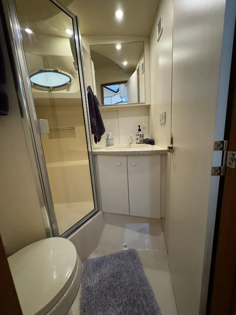 Slide: The Image of Compact bathroom in a 1989 Sea Ray 39 boat with shower, sink, and toilet. - 23