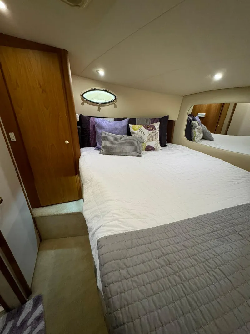 Slide: The Image of Cozy bedroom in 1989 Sea Ray 39 yacht with plush bedding and wooden accents. - 25