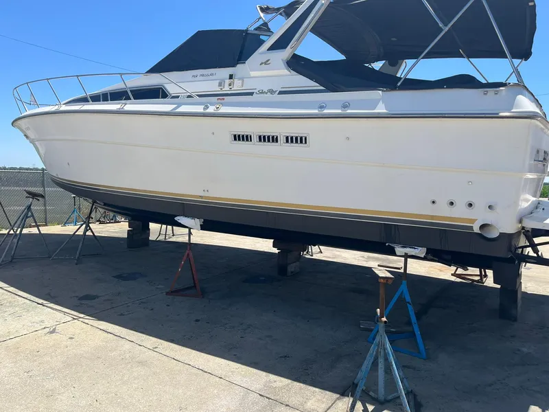 Slide: The Image of 1989 Sea Ray 39 boat on stands, white hull, outdoor setting. - 3