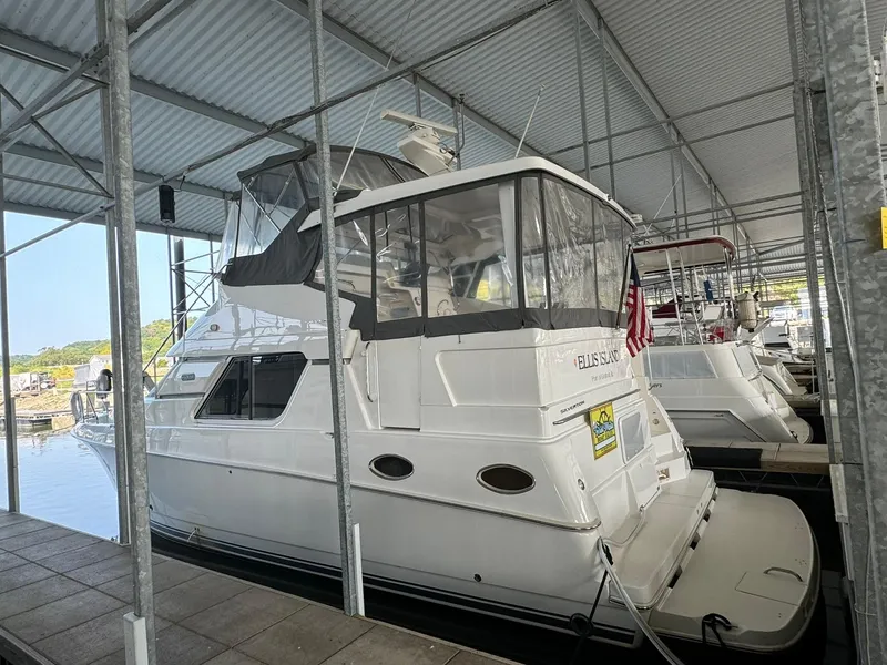 Slide: The Image of 1989 Sea Ray 39 yacht docked in a covered marina, featuring a sleek white design. - 32