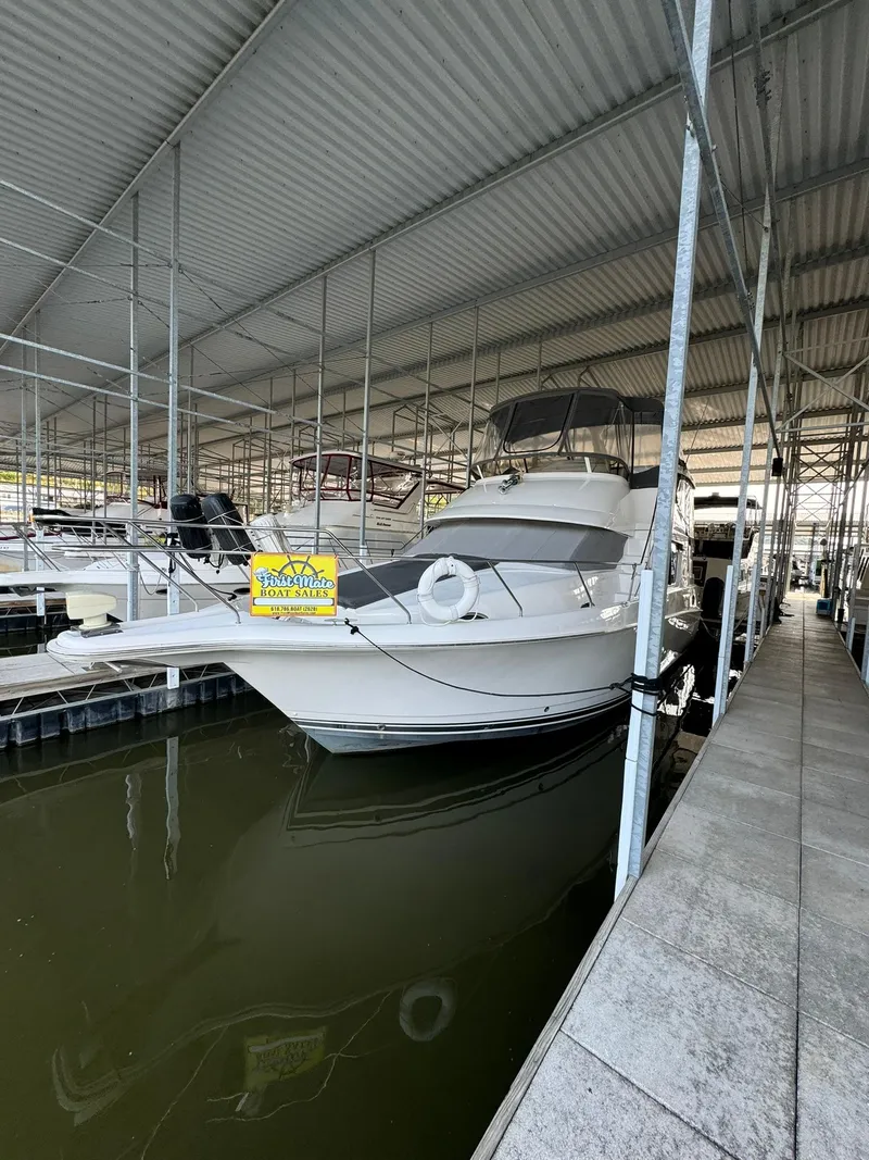Slide: The Image of 1989 Sea Ray 39 boat docked in covered marina, for sale sign visible. - 38