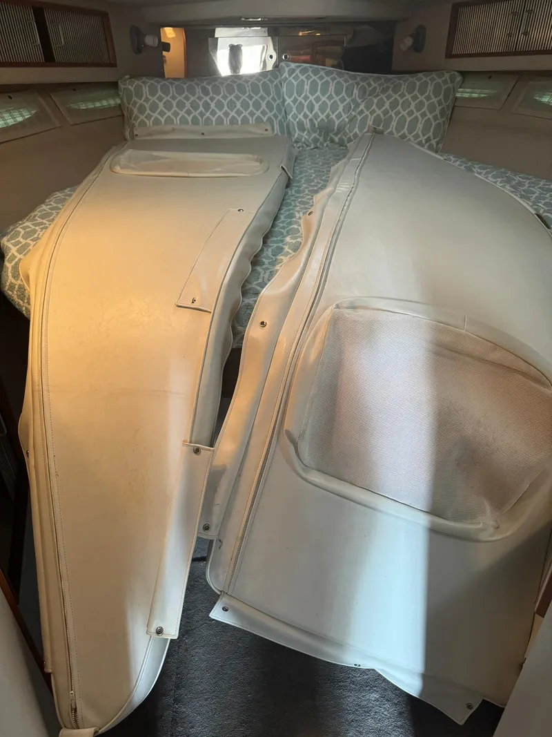 Slide: The Image of Interior cabin of 1989 Sea Ray 39 with white cushions and patterned bedding. - 41
