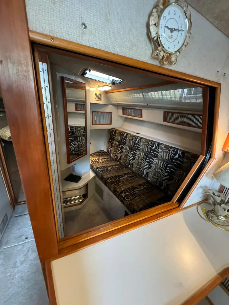 Slide: The Image of Interior of 1989 Sea Ray 39 boat with patterned seating and wall clock. - 45