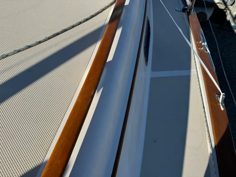 Slide: The Image of Close-up of 1998 Island Packet 40 sailboat deck with wood trim and textured surface. - 11