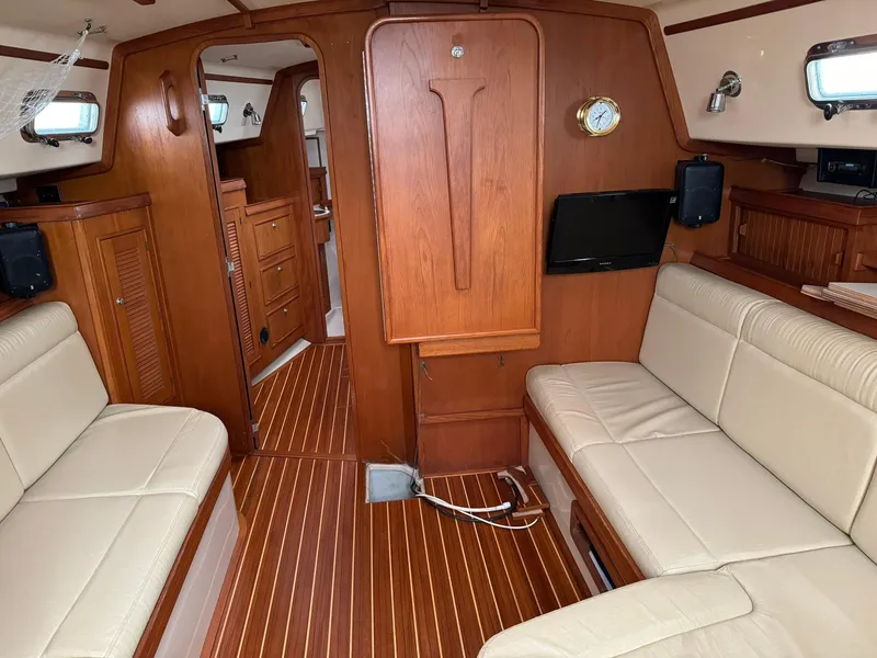 Slide: The Image of Interior of 1998 Island Packet 40 sailboat with wood paneling and beige seating. - 22