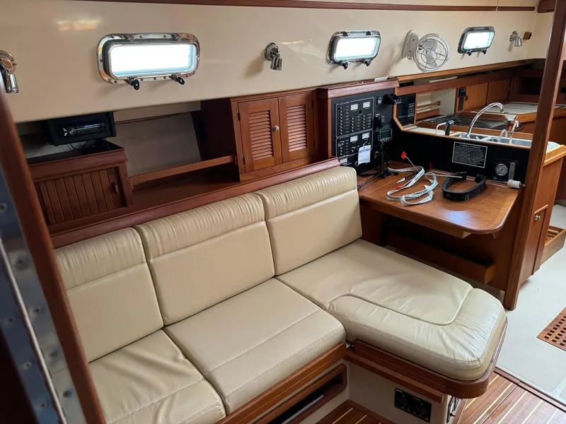 Slide: The Image of Interior of 1998 Island Packet 40 sailboat with beige seating and navigation station. - 24