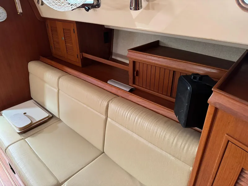 Slide: The Image of Interior of 1998 Island Packet 40 sailboat with beige seating and wooden cabinetry. - 26