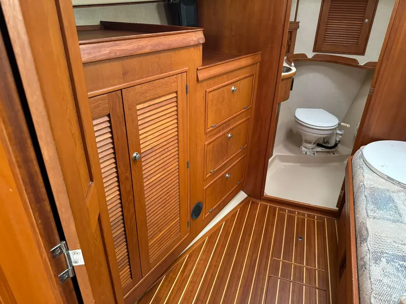 Slide: The Image of Interior of 1998 Island Packet 40 sailboat with wooden cabinetry and marine toilet. - 28