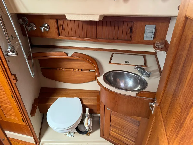 Slide: The Image of 1998 Island Packet 40 yacht bathroom with wooden cabinetry and stainless steel sink. - 36