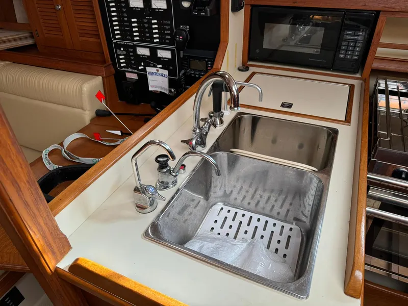 Slide: The Image of Island Packet 40 yacht kitchen sink area with dual faucets and microwave, 1998 model. - 38
