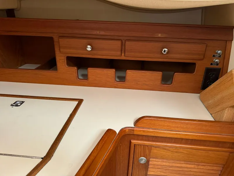 Slide: The Image of Interior of 1998 Island Packet 40 sailboat with wooden cabinetry and storage compartments. - 39