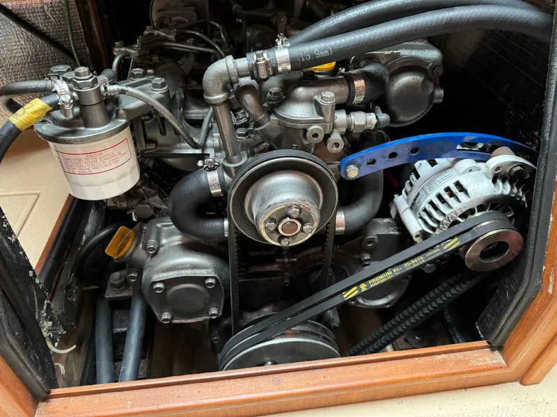 Slide: The Image of Engine compartment of a 1998 Island Packet 40 sailboat, showing belts and components. - 47