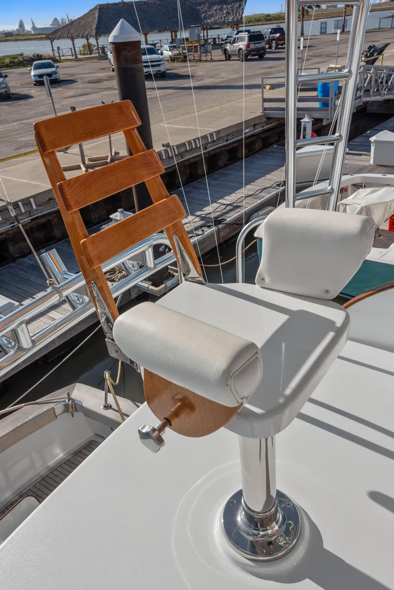 Slide: The Image of 1963 Whiticar 54 Sportfisherman boat with wooden and white cushioned seating on deck. - 17