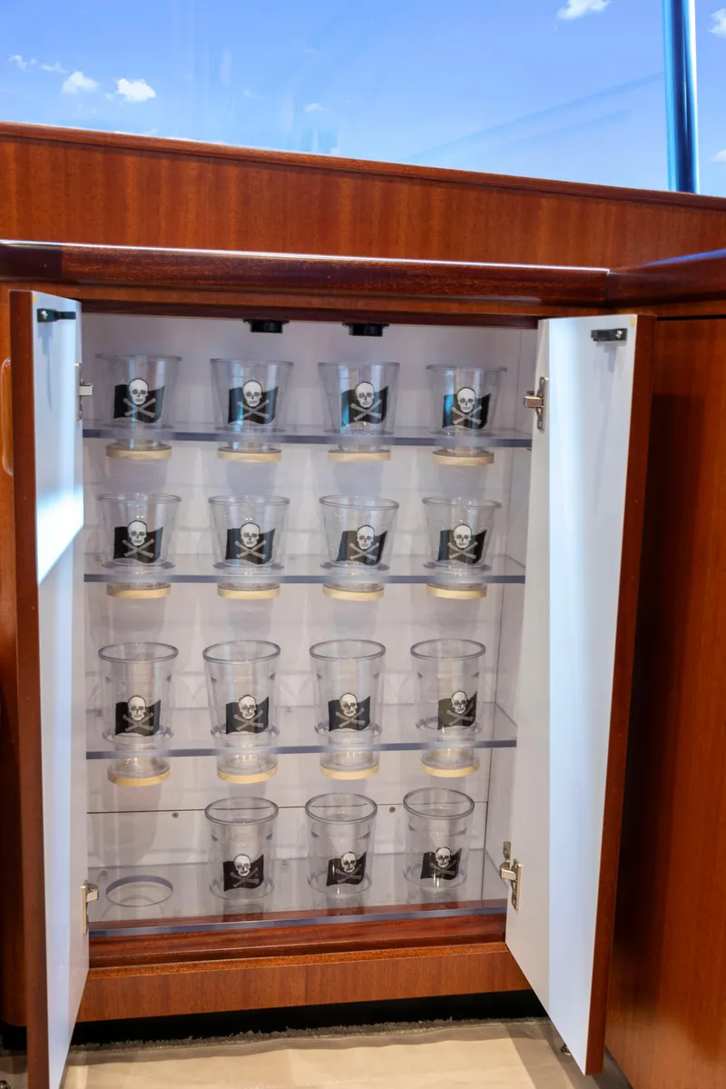 Slide: The Image of Open cabinet with skull-printed glasses on a 1963 Whiticar 54 Sportfisherman yacht. - 32