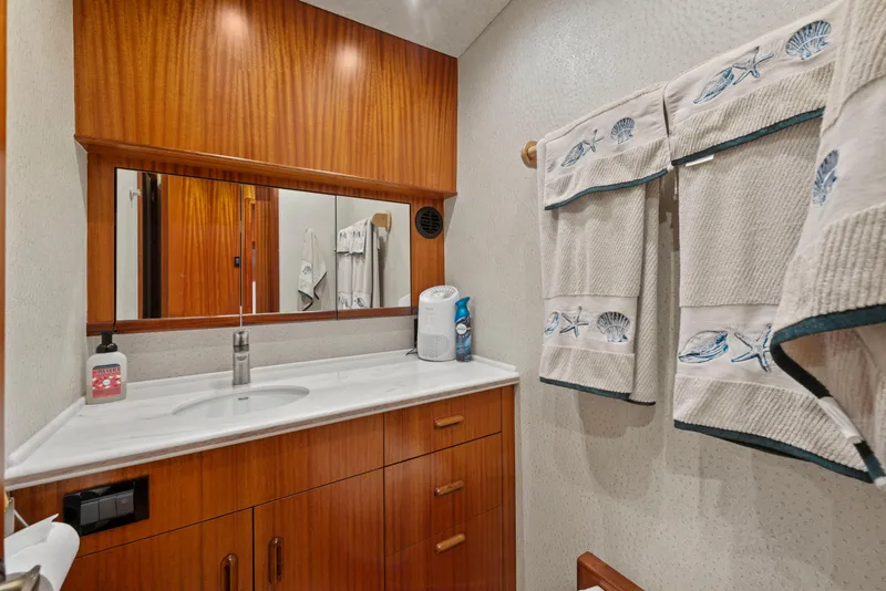 Slide: The Image of Luxurious bathroom in 1963 Whiticar 54 Sportfisherman yacht with wooden cabinetry and nautical-themed towels. - 43