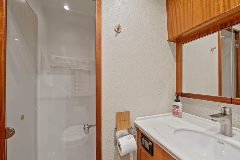 Slide: The Image of 1963 Whiticar 54 Sportfisherman bathroom with shower, sink, and wooden cabinetry. - 44