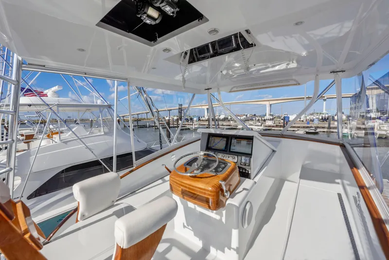 Slide: The Image of 1963 Whiticar 54 Sportfisherman helm with modern controls, docked in a marina. - 8