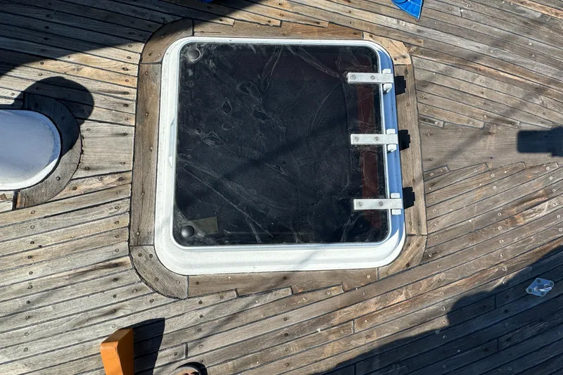 Slide: The Image of Deck hatch on 1984 Transpacific Marine Ketch with wooden planks and metal hinges. - 16