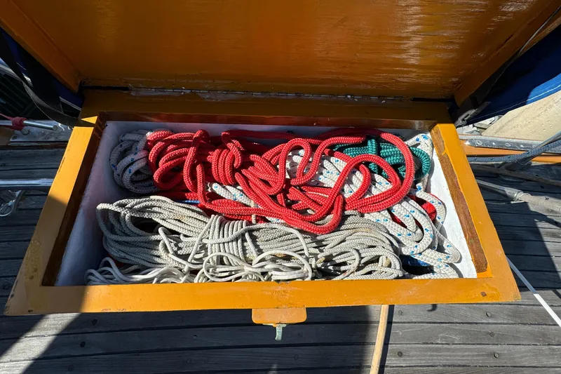 Slide: The Image of Colorful ropes stored in a wooden compartment on a 1984 Transpacific Marine Ketch. - 29