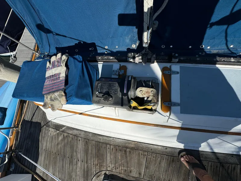 Slide: The Image of 1984 Transpacific Marine Ketch deck with winch, gloves, and blue cover. - 32