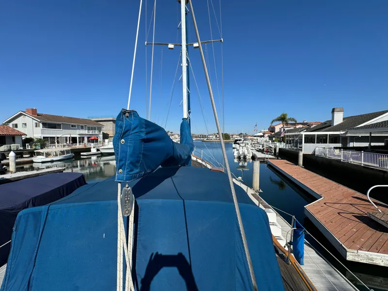 Slide: The Image of 1984 Transpacific Marine Ketch docked in a sunny marina, blue sails covered. - 34