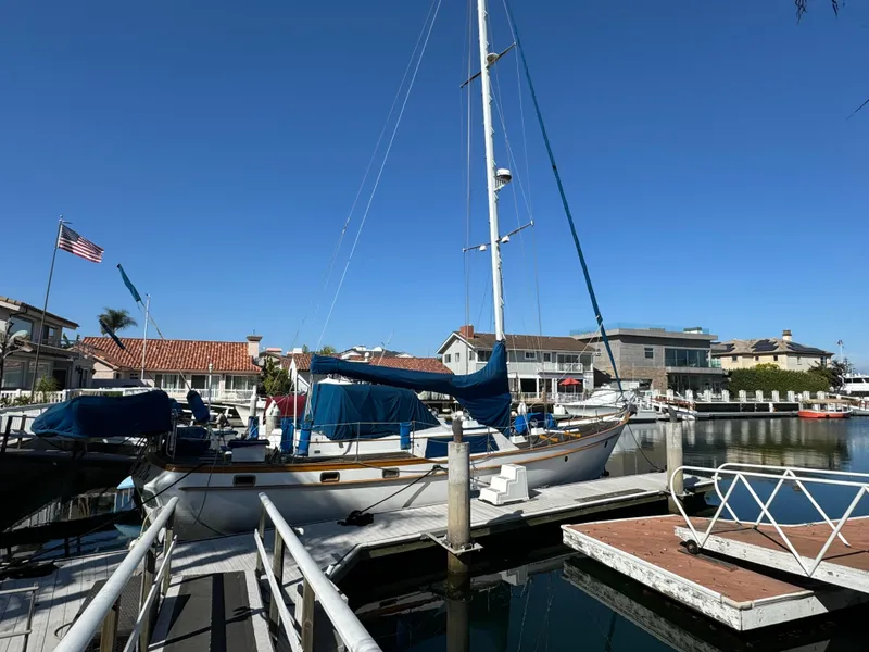Slide: The Image of 1984 Transpacific Marine Ketch docked in a sunny marina with clear blue skies. - 4