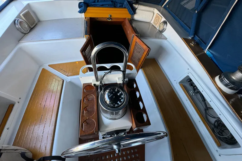 Slide: The Image of 1984 Transpacific Marine Ketch cockpit with compass, wooden seating, and open cabin doors. - 40