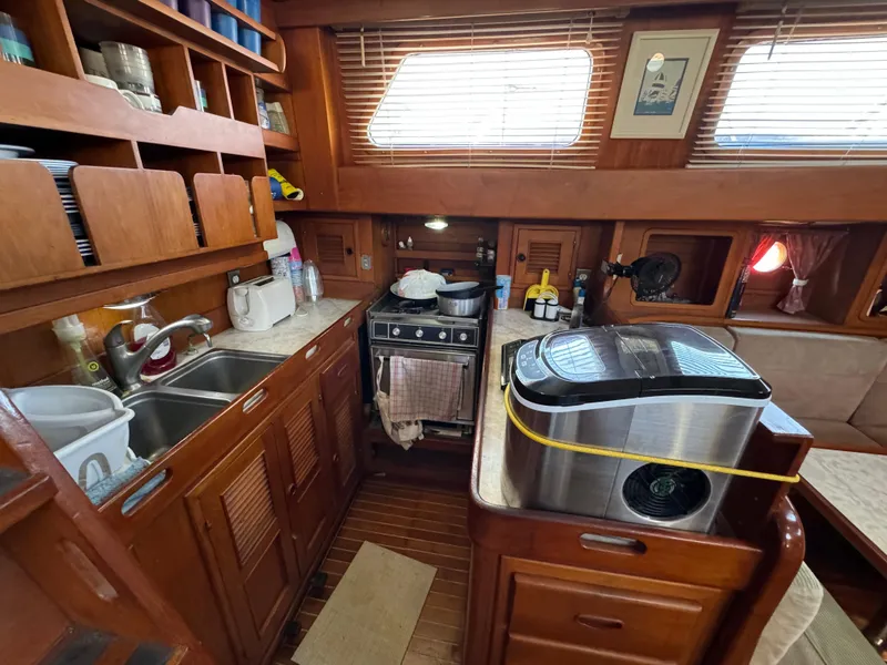 Slide: The Image of 1984 Transpacific Marine Ketch interior kitchen with wooden cabinetry and modern appliances. - 48