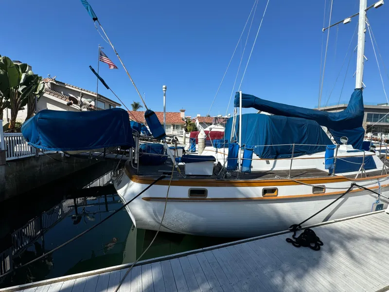 Slide: The Image of 1984 Transpacific Marine Ketch docked at marina, blue covers, clear sky. - 6