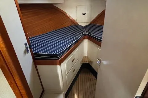 Slide: The Image of 1977 Bertram 35 Convertible cabin with striped bedding and wooden accents. - 14