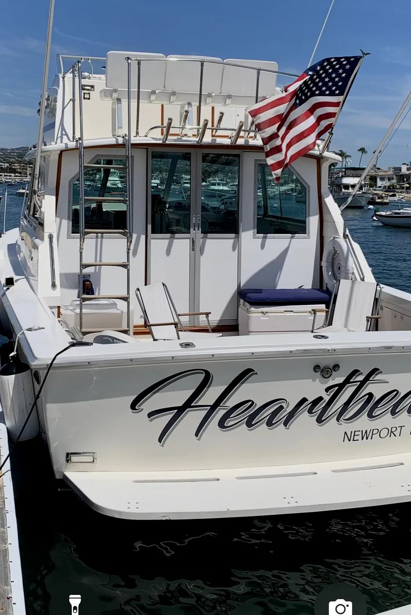 Slide: The Image of 1977 Bertram 35 Convertible boat with American flag, docked in Newport harbor. - 22